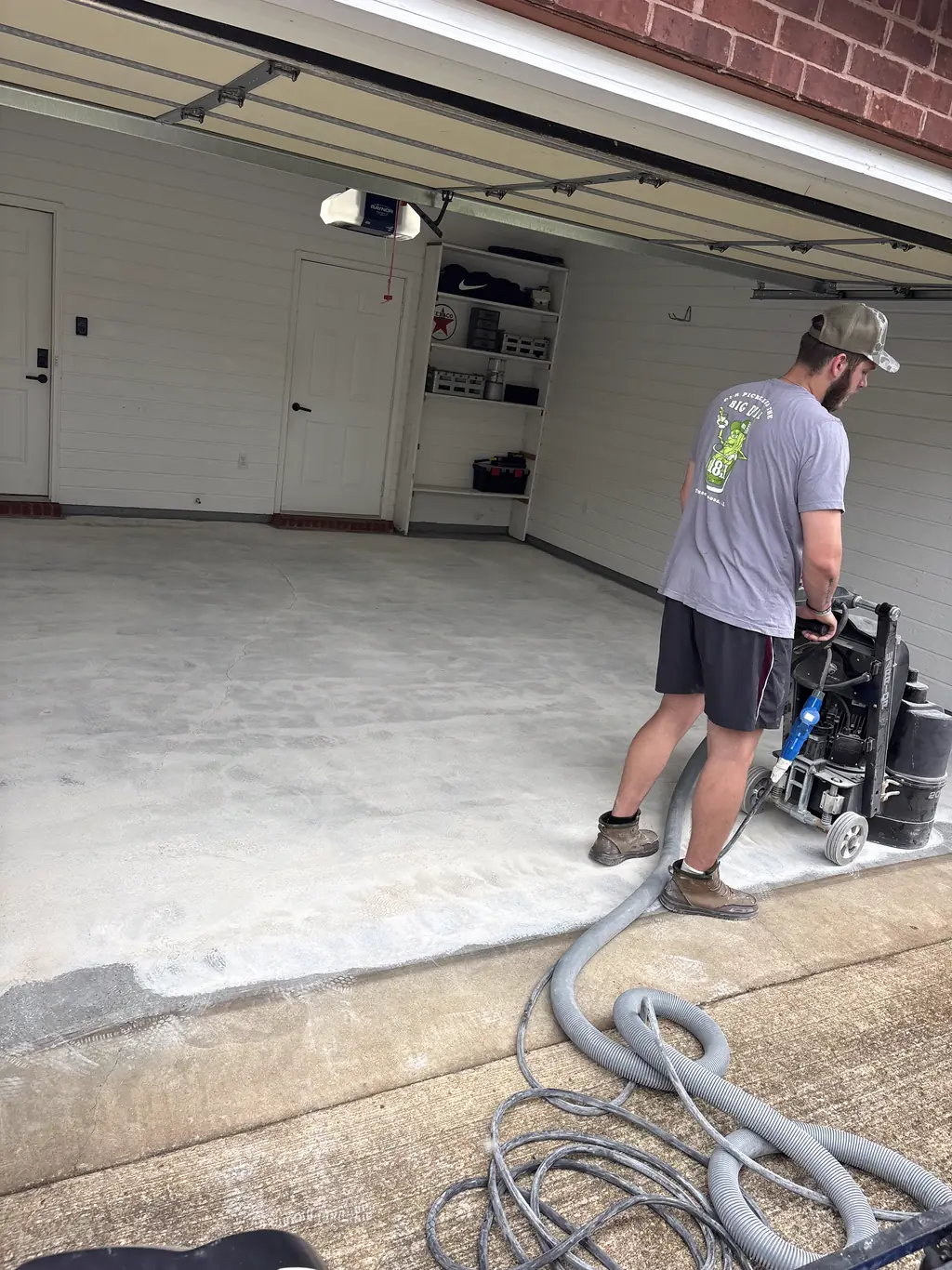 Diamond grinding a concrete garage slab with a dust collector before coating