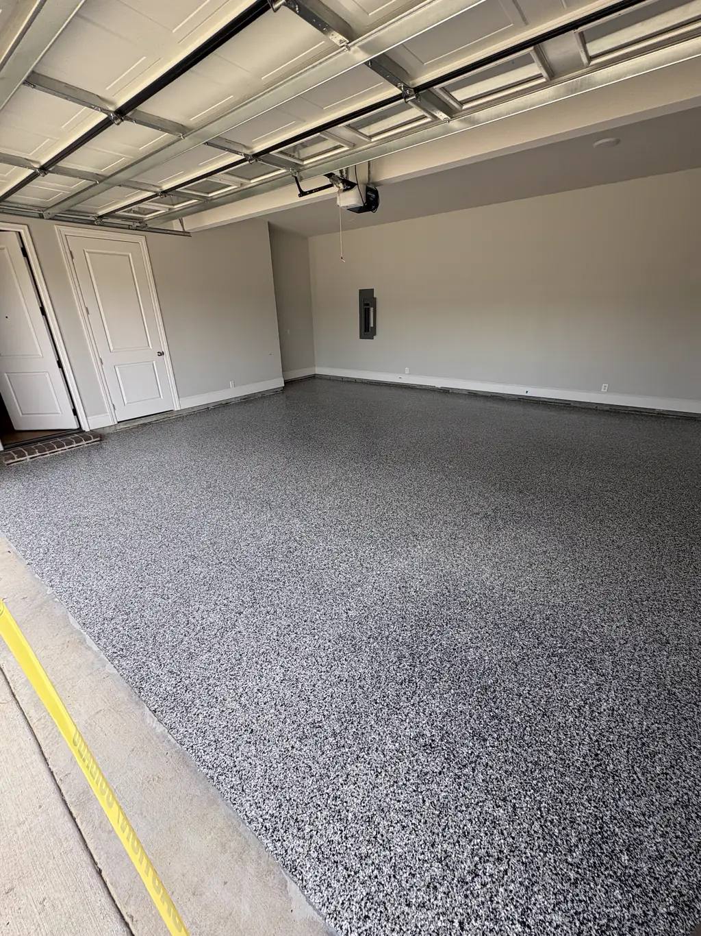 Three car garage with a speckled gray flake epoxy floor