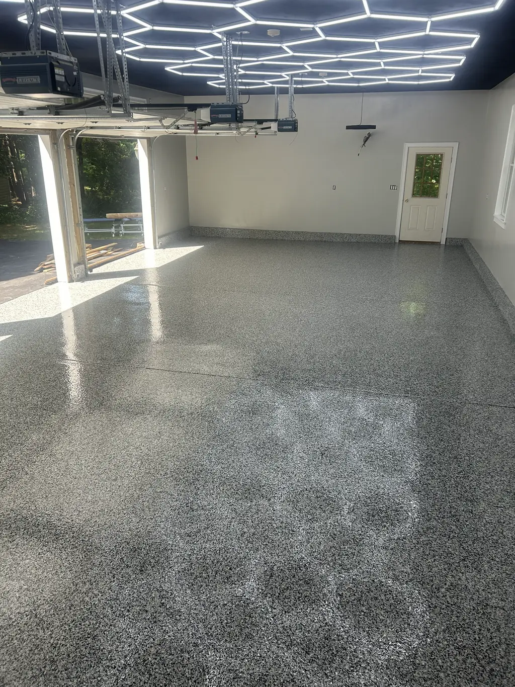 Wide shop floor finished in gray flake epoxy with a high gloss topcoat