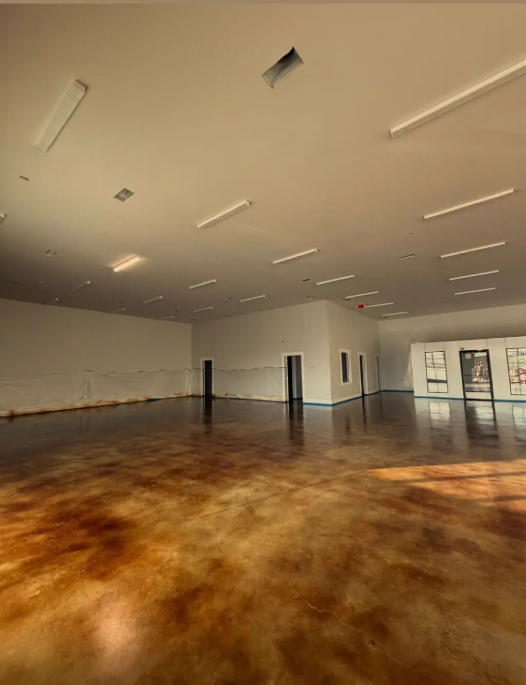 Large open room with amber acid stained concrete flooring
